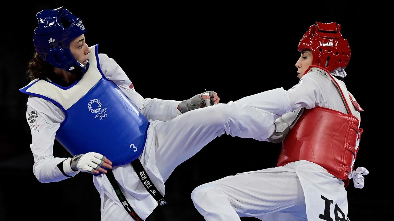 Refugee Olympic Team's Kimia Alizadeh (Blue) and Iran's Nahid Kiyani Chandeh (Red) compete in the taekwondo women's -57kg elimination round bout during the Tokyo 2020 Olympic Games at the Makuhari Messe Hall in Tokyo on July 25, 2021.