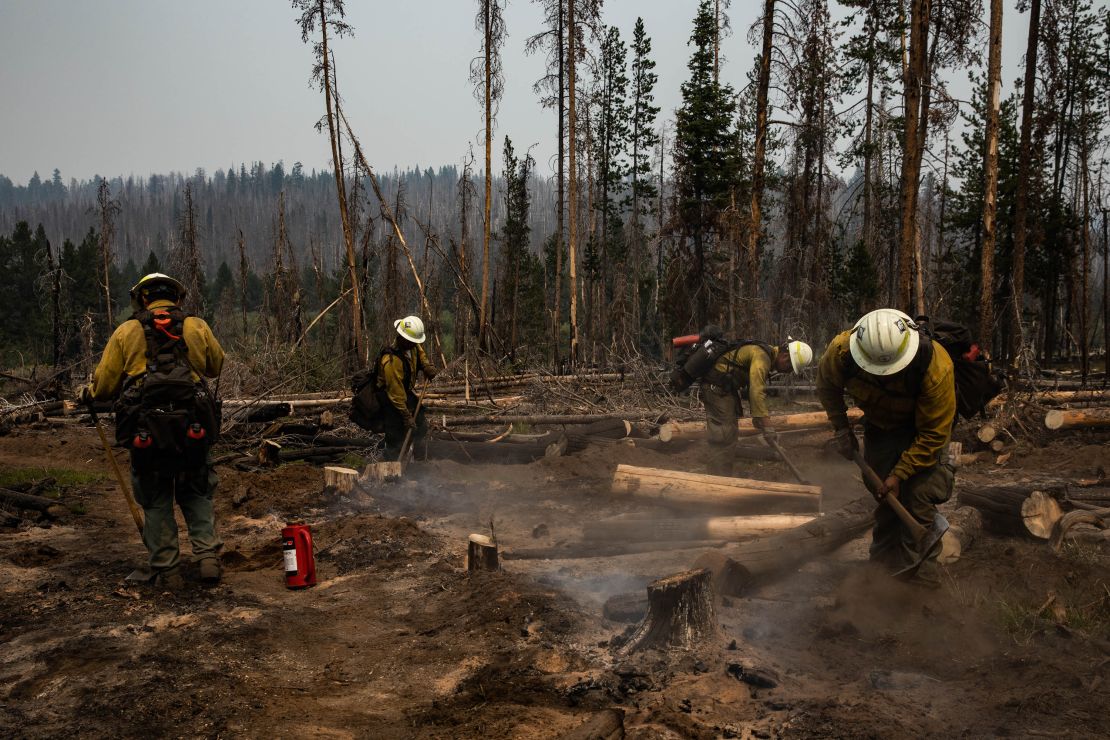 A firefighter crew from New Mexico mops up small fires in the mountains west of Paisley, Oregon, on Friday, July 23, 2021.