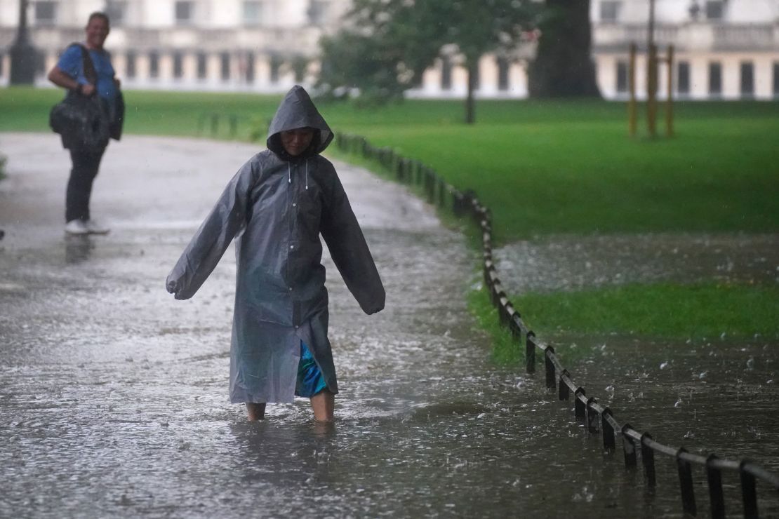 A pedestrian walks through a flooded area in St James's Park in central London on Sunday.