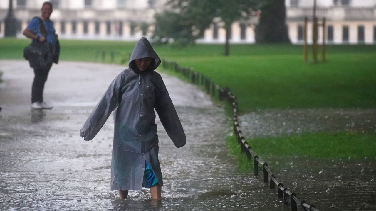 A pedestrian walks through a flooded area in St James's Park in central London on Sunday.
