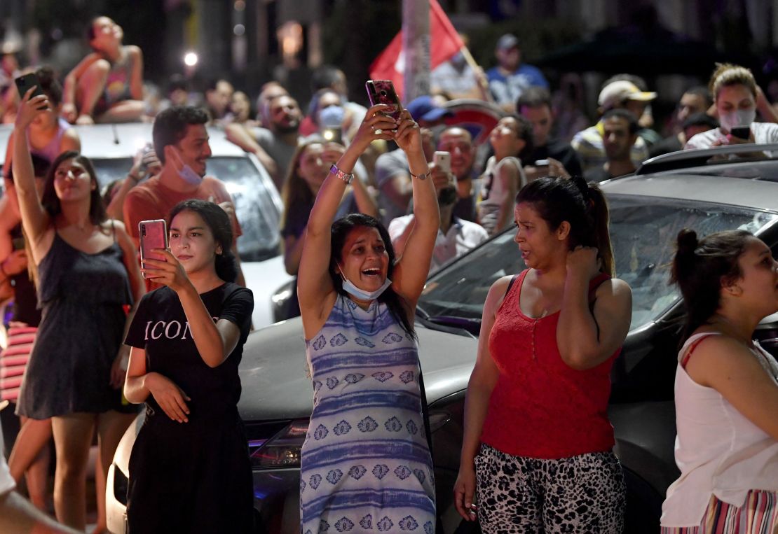People celebrate in the street after Tunisian President Kais Saied announced the dissolution of parliament and Prime Minister Hichem Mechichi's government in Tunis on July 25, 2021.