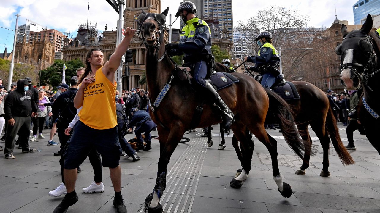 A protester tries to push away a police horse in Sydney on July 24, as thousands of people protest against the city's month-long stay-at-home orders. It is not clear if the person in the photo is one of the two men charged. 