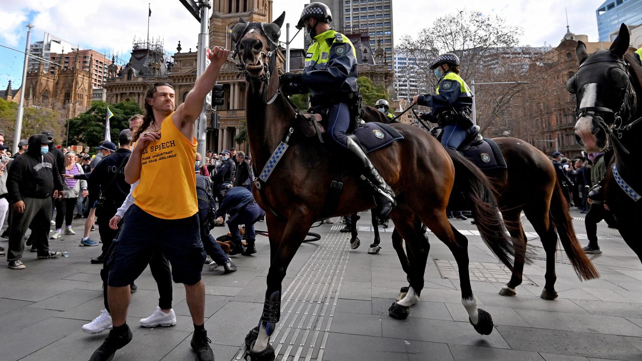 A protester tries to push away a police horse in Sydney on July 24, as thousands of people protest against the city's month-long stay-at-home orders. It is not clear if the person in the photo is one of the two men charged.