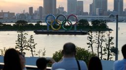 Visitors look at the Olympic rings floating in the water at Odaiba Marine Park, where triathlon and marathon swimming events will be held, on the eve of the pandemic-delayed 2020 Summer Olympics, Sunday, July 25, 2021, in Tokyo, Japan. (AP Photo/Eugene Hoshiko)