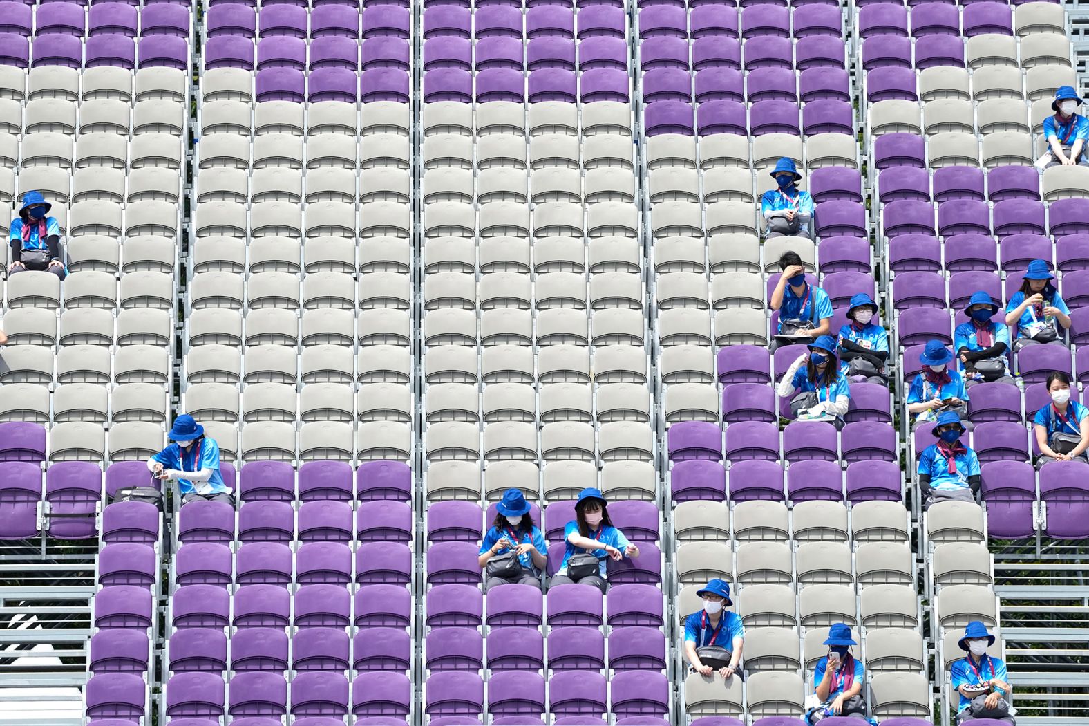 Volunteers sit in mostly empty stands during archery competition on July 26.