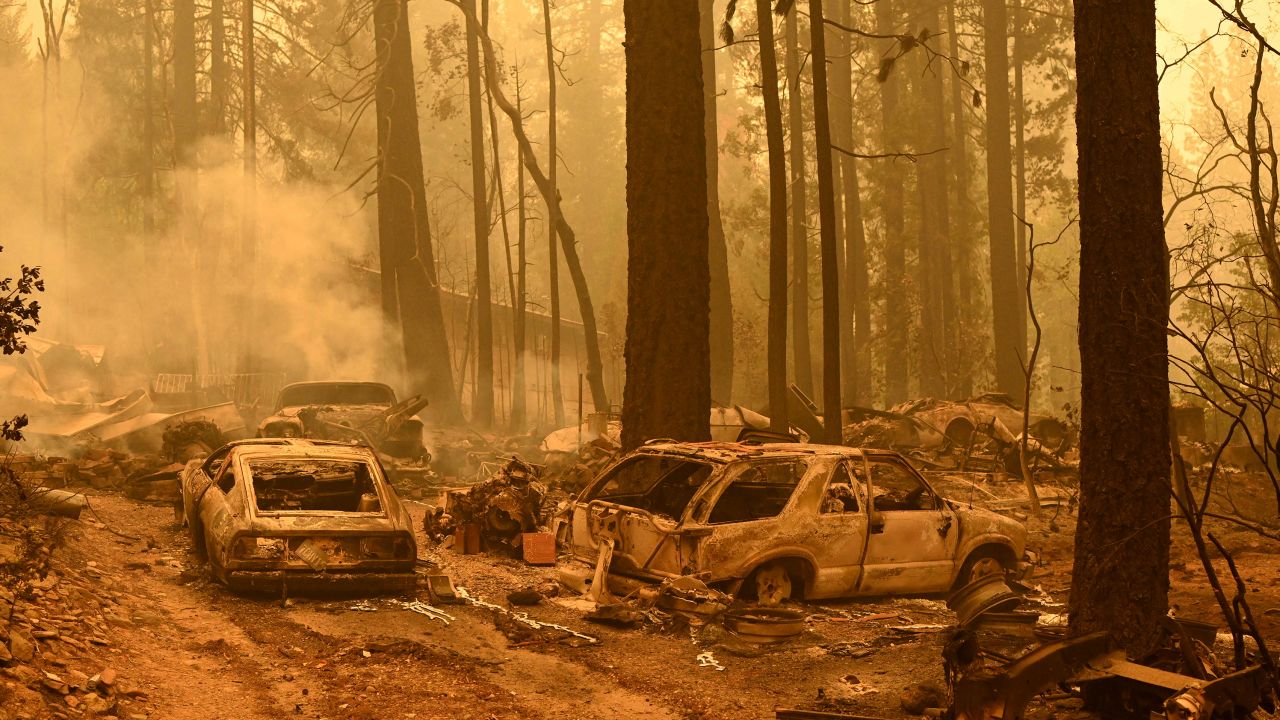 Burned vehicles smolder at a property during the Dixie fire in the Indian Falls area of unincorporated Plumas County.