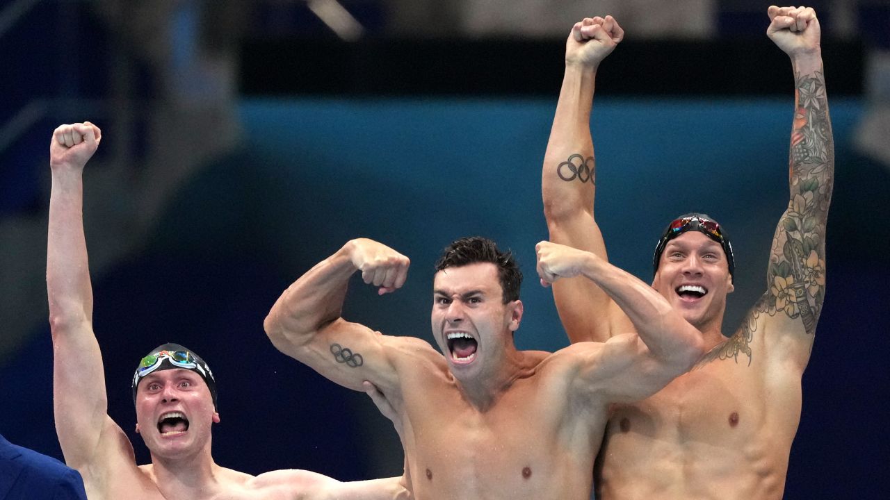 United States men's 4x100m freestyle relay team Bowen Becker, Blake Pieroni and Caeleb Dressel celebrate after winning the gold medal at the 2020 Summer Olympics on Monday, July 26, 2021, in Tokyo, Japan. Dressel has a full sleeve on his left arm, while Pieroni sports the Olympic rings.