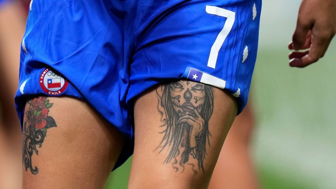 Women's soccer player Yenny Acuna of Chile warms up before the match against Canada on Saturday, July 24, 2021, in Sapporo, Japan. Acuna has two thigh tattoos, pictured here, along with a full sleeve on her arm.
