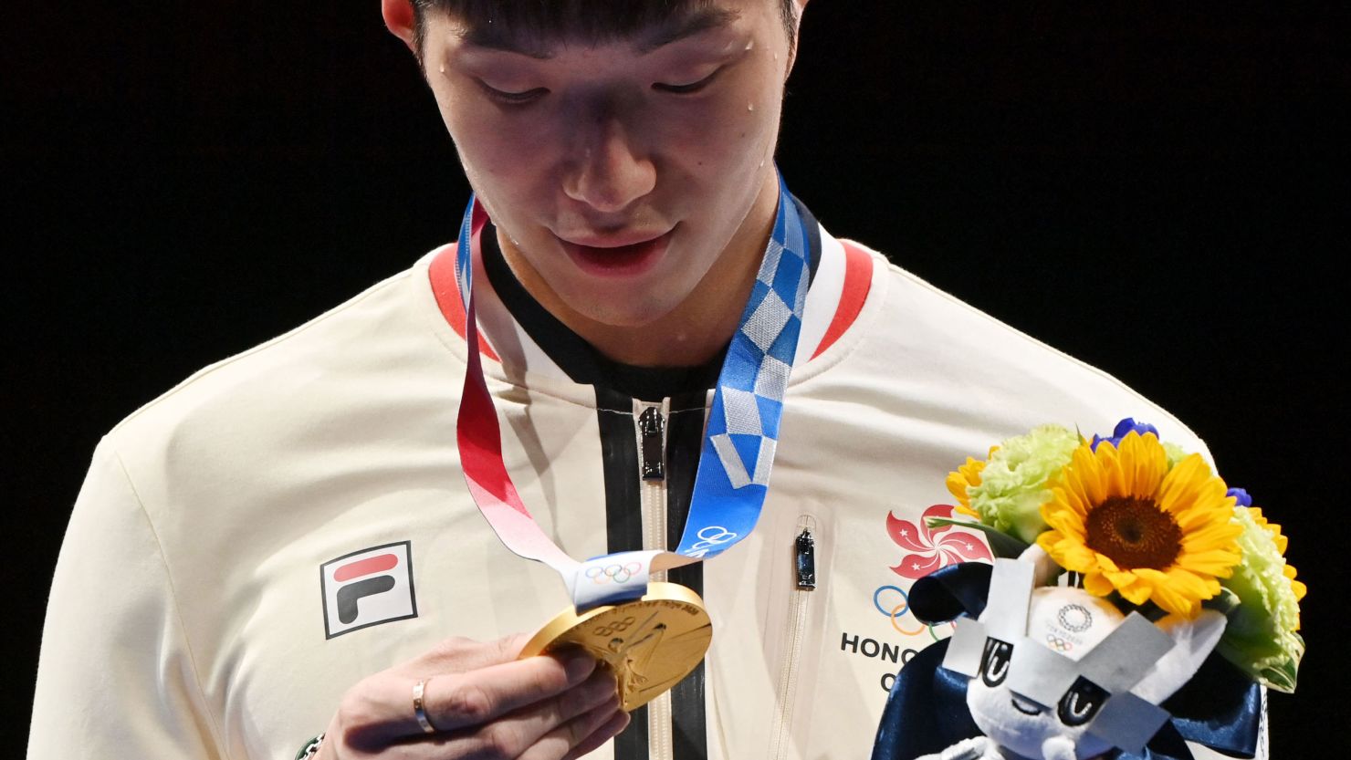 Fencing gold medallist Cheung Ka Long of Hong Kong looks at his medal while on the podium during the medal ceremony for the Men's Individual Foil during the Tokyo 2020 Olympic Games at the Makuhari Messe Hall in Chiba City, Chiba Prefecture, Japan, on July 26, 2021. 