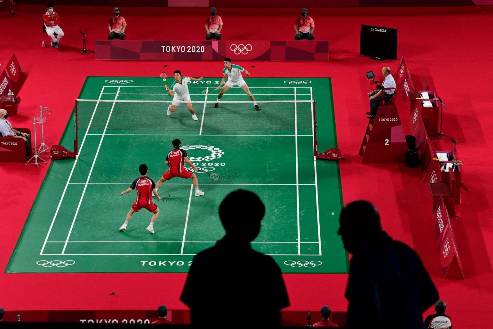 Members of the media are pictured in the foreground as Indonesia's Marcus Fernaldi Gideon, bottom left, and Kevin Sanjaya Sukamuljo play a badminton match against Taiwan's Lee Yang, top left, and Wang Chi-lin on July 27.