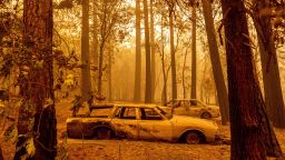 Following the Dixie Fire, scorched cars are seen in a clearing in the Indian Falls community of Plumas County, California.
