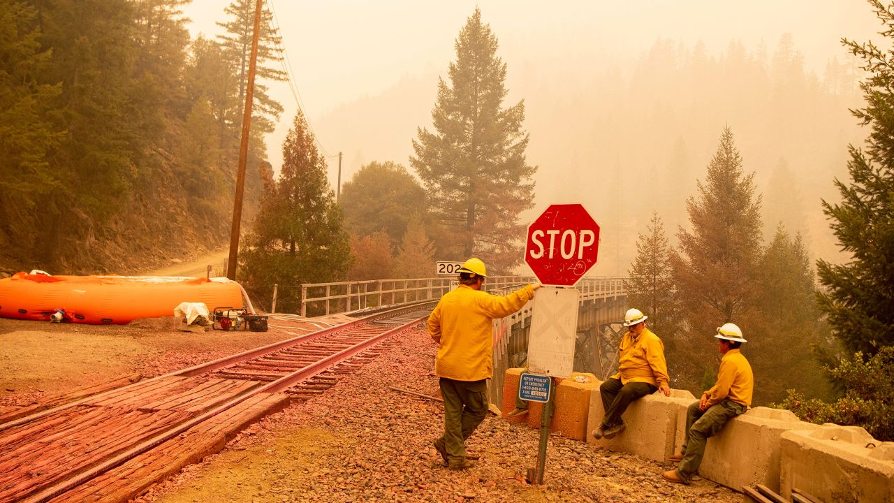 Employees of the Burlington Northern Santa Fe train lines protect train tracks with a mobile sprinkler system during the Dixie fire in Quincy, California, on July 26.