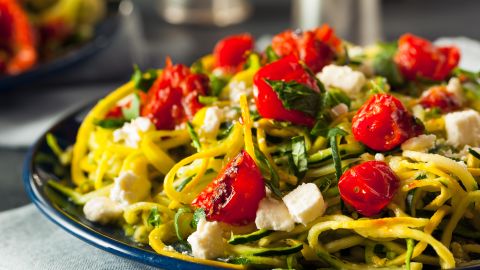 Zucchini noodle pasta is served here with tomatoes and feta.