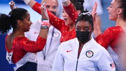 Tokyo 2020 Olympics - Gymnastics - Artistic - Women's Team - Final - Ariake Gymnastics Centre, Tokyo, Japan - July 27, 2021. Simone Biles of the United States wearing a protective face mask looks on as Jordan Chiles of the United States celebrates with Sunisa Lee of the United States and Grace McCallum of the United States in the background REUTERS/Dylan Martinez