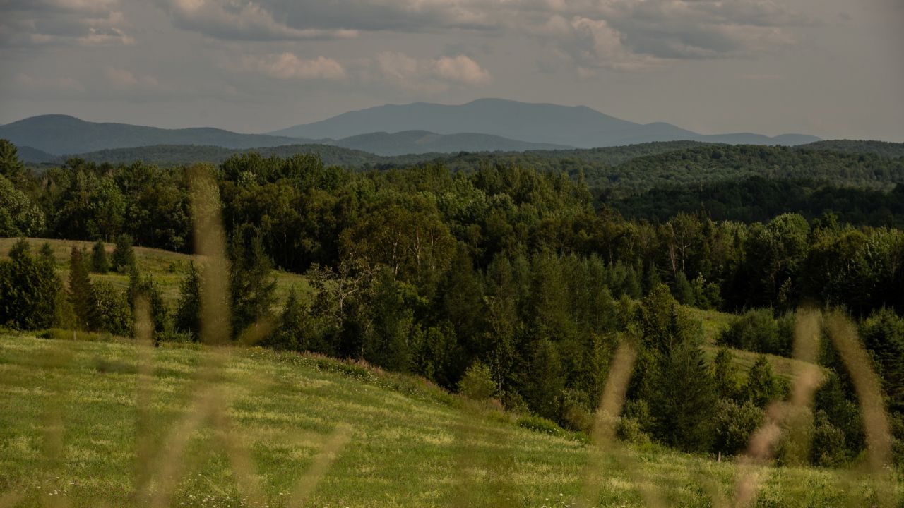 Mountains rise over the Vermont countryside in Caledonia County. Neighboring Essex County has the lowest vaccination rate in the state.