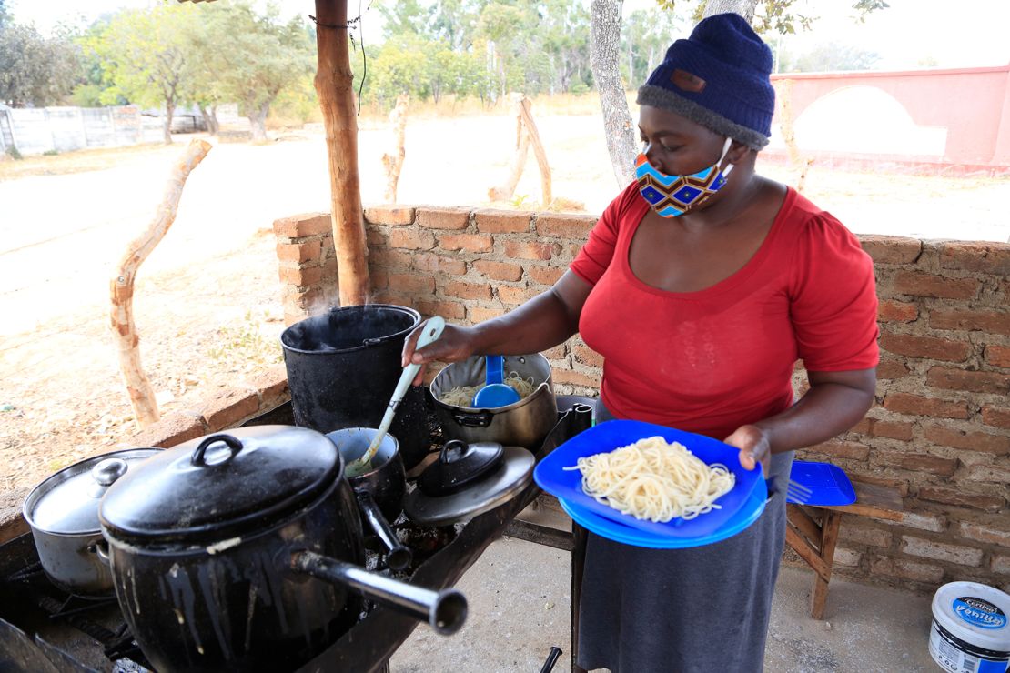 Pauline Chinyandura serves a plate of lunch.
