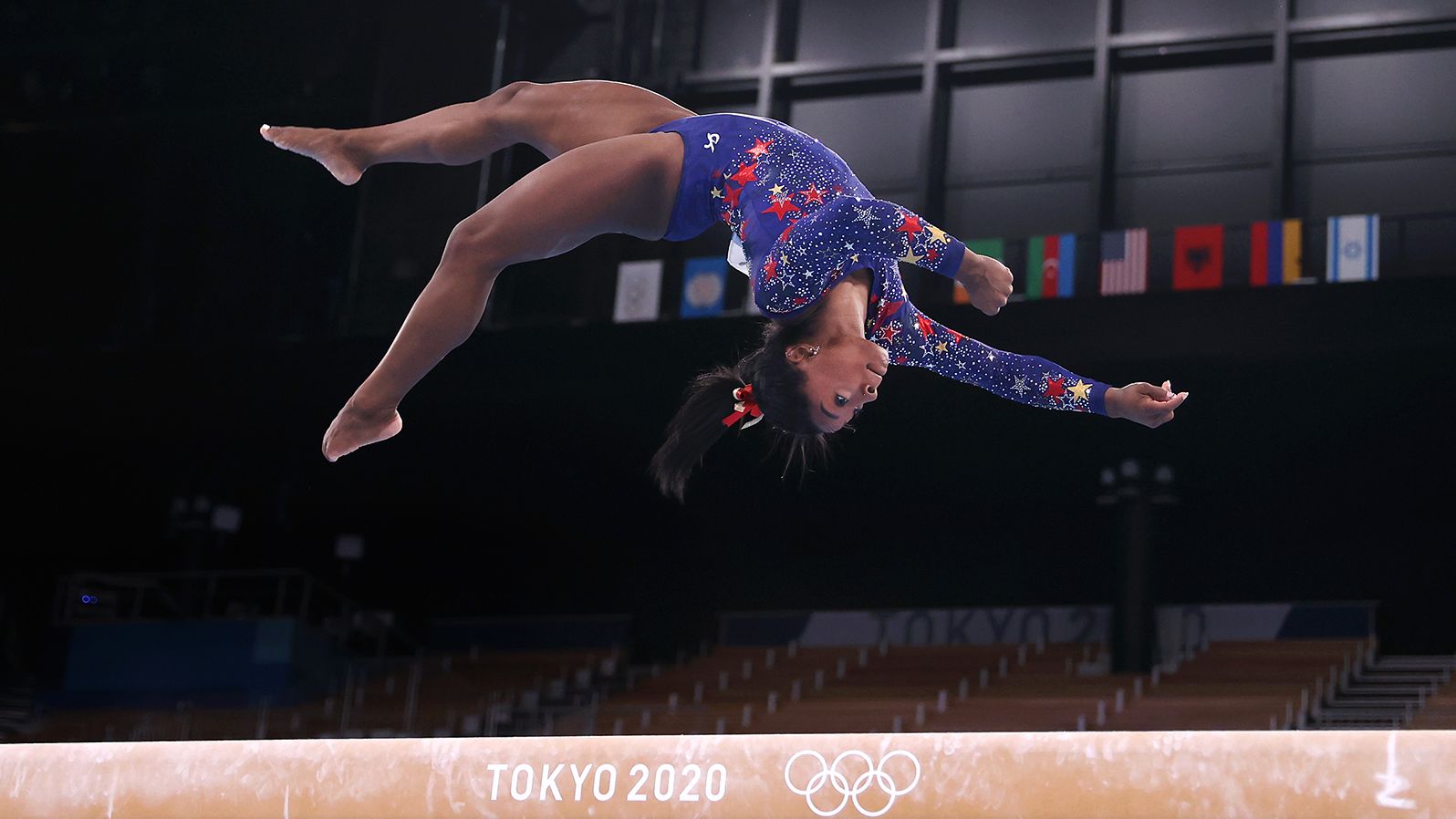Simone Biles does a flip on the balance beam at the Tokyo Olympic Games. 