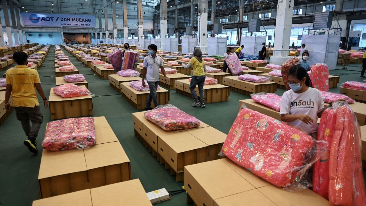 Workers prepare mattresses and blankets for some 1,800 cardboard beds at a Covid-19 field hospital inside a warehouse at the Don Mueang International Airport in Bangkok on July 27.