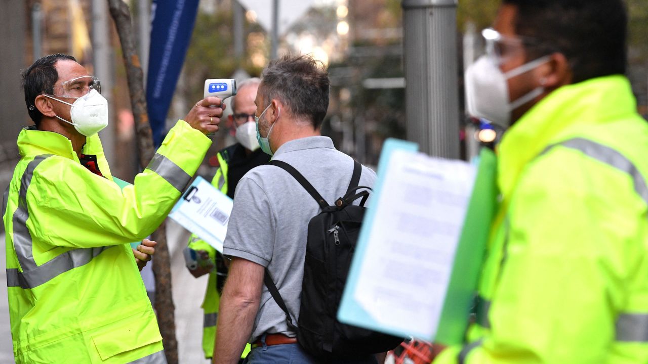 A health official checks the temperature of a resident at a Covid-19 vaccination centre in Sydney on July 27, 2021.