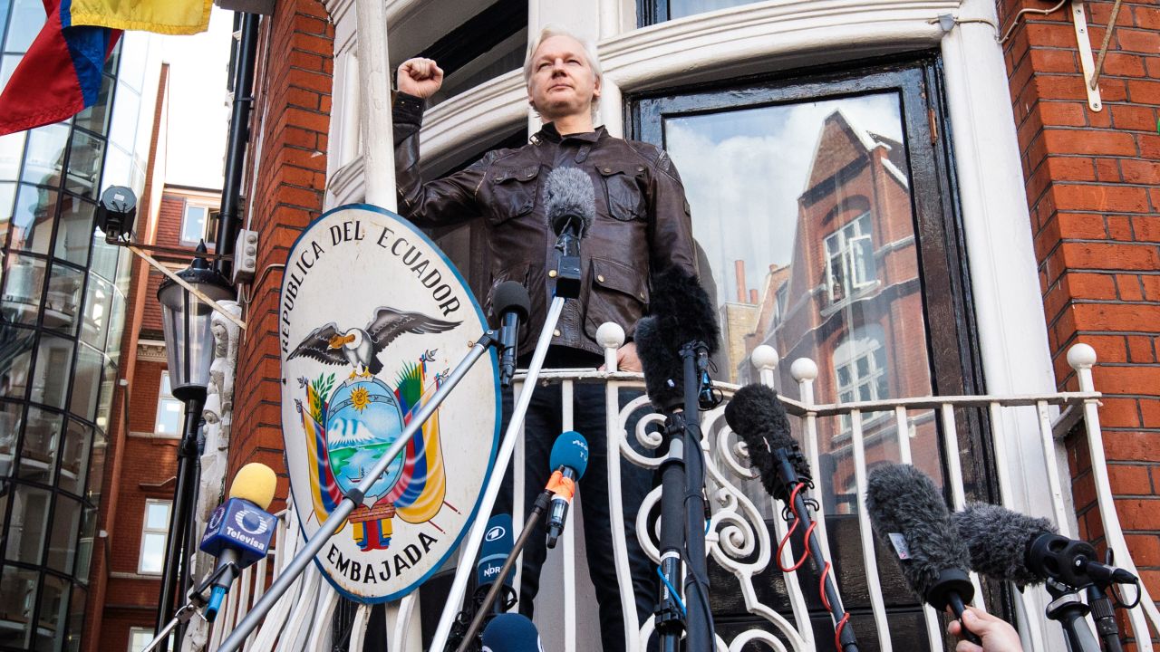 Julian Assange raises his fist as he steps out to speak to the media from the balcony of the Embassy Of Ecuador on May 19, 2017 in London.