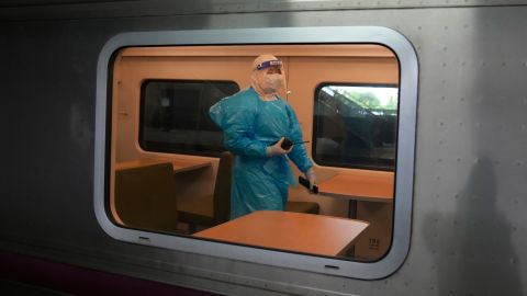 A health worker with protective gear walks inside a carriage as the train prepares to carry a group of Covid-19 patients to their hometowns, at Rangsit station in Pathum Thani province, Thailand, on July 27.