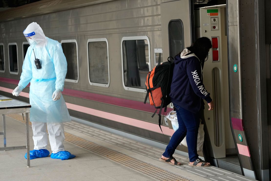 A Covid-19 patient boards a train at Rangsit station on the outskirts of Bangkok to head to her hometown on July 27.