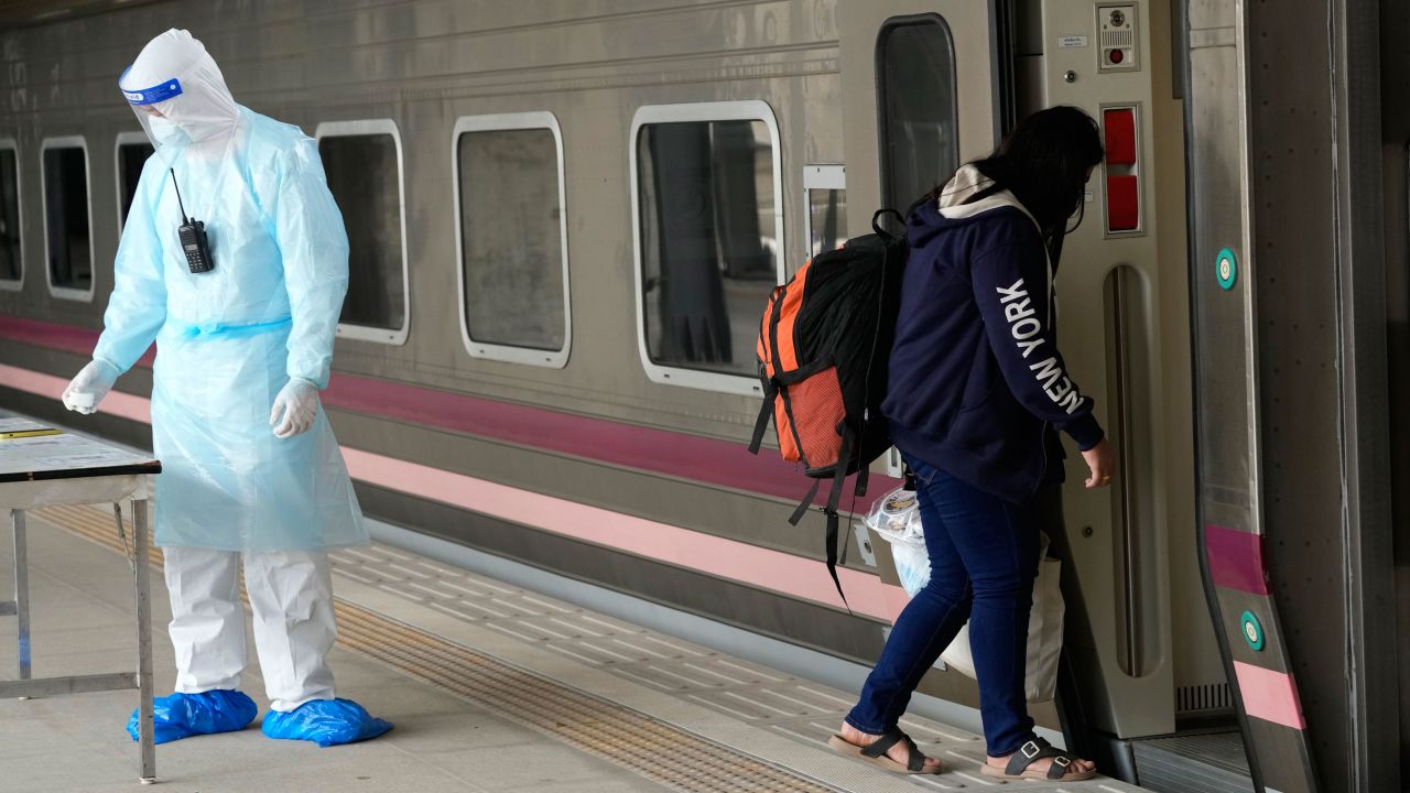A Covid-19 patient boards a train at Rangsit station on the outskirts of Bangkok to head to her hometown on July 27.