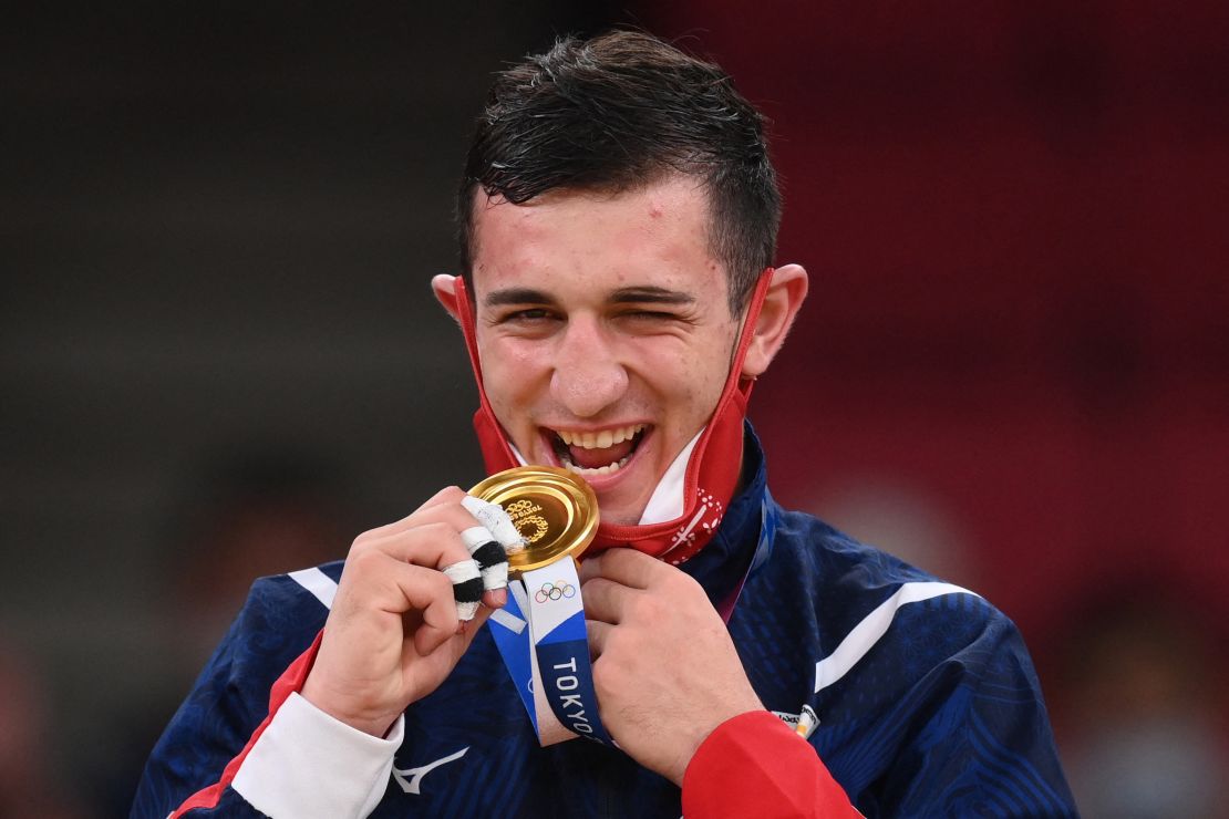 Gold medalist Lasha Bekauri of Georgia nibbling his prize during the medal ceremony for the judo men's -90kg contest.