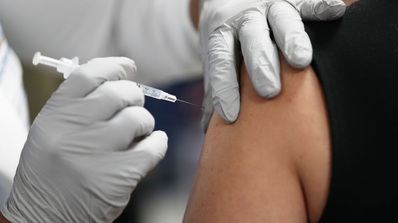 MIAMI, FLORIDA - DECEMBER 15: A healthcare worker at the Jackson Health Systems receives a Pfizer-BioNtech Covid-19 vaccine from Susana Flores Villamil, RN from Jackson Health Systems, at the Jackson Memorial Hospital on December 15, 2020 in Miami, Florida.  Jackson Memorial Hospital began the vaccination of frontline healthcare workers joining with hospital systems around the country as the COVID-19 vaccine is rolled out. (Photo by Joe Raedle/Getty Images)