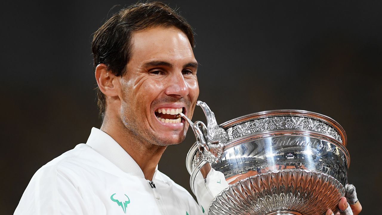 Nadal bites the Coupe des Mousquetaires following victory at the French Open.