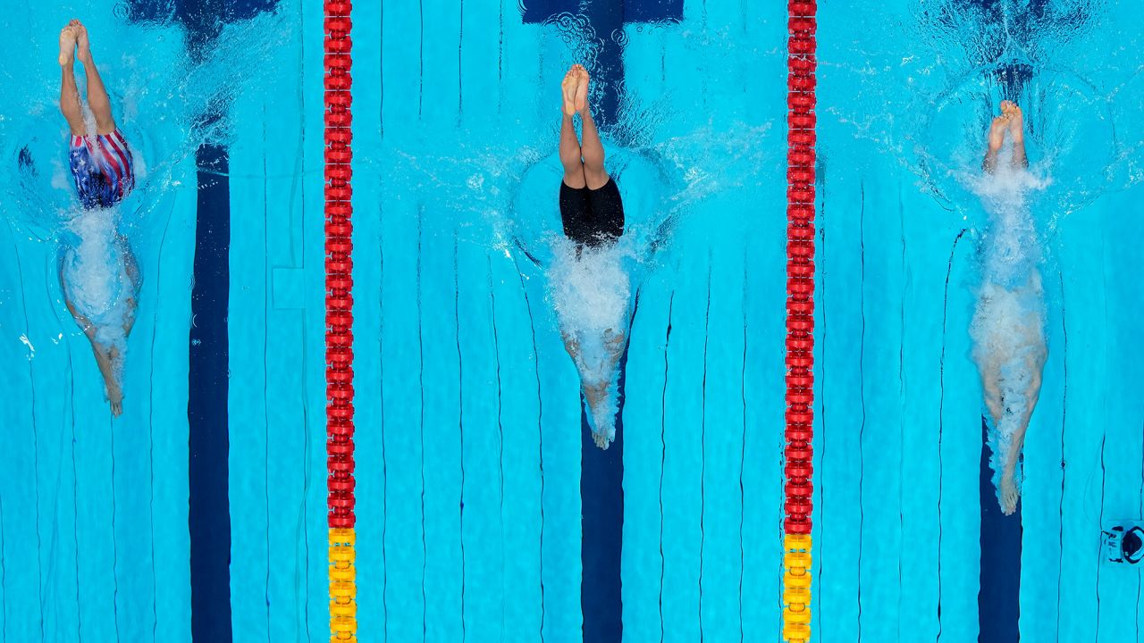 From left, the United States' Bobby Finke, Ukraine's Mykhailo Romanchuk and Germany's Florian Wellbrock dive in the water at the start of the 800-meter freestyle final on July 29. Finke won gold after a late rally.