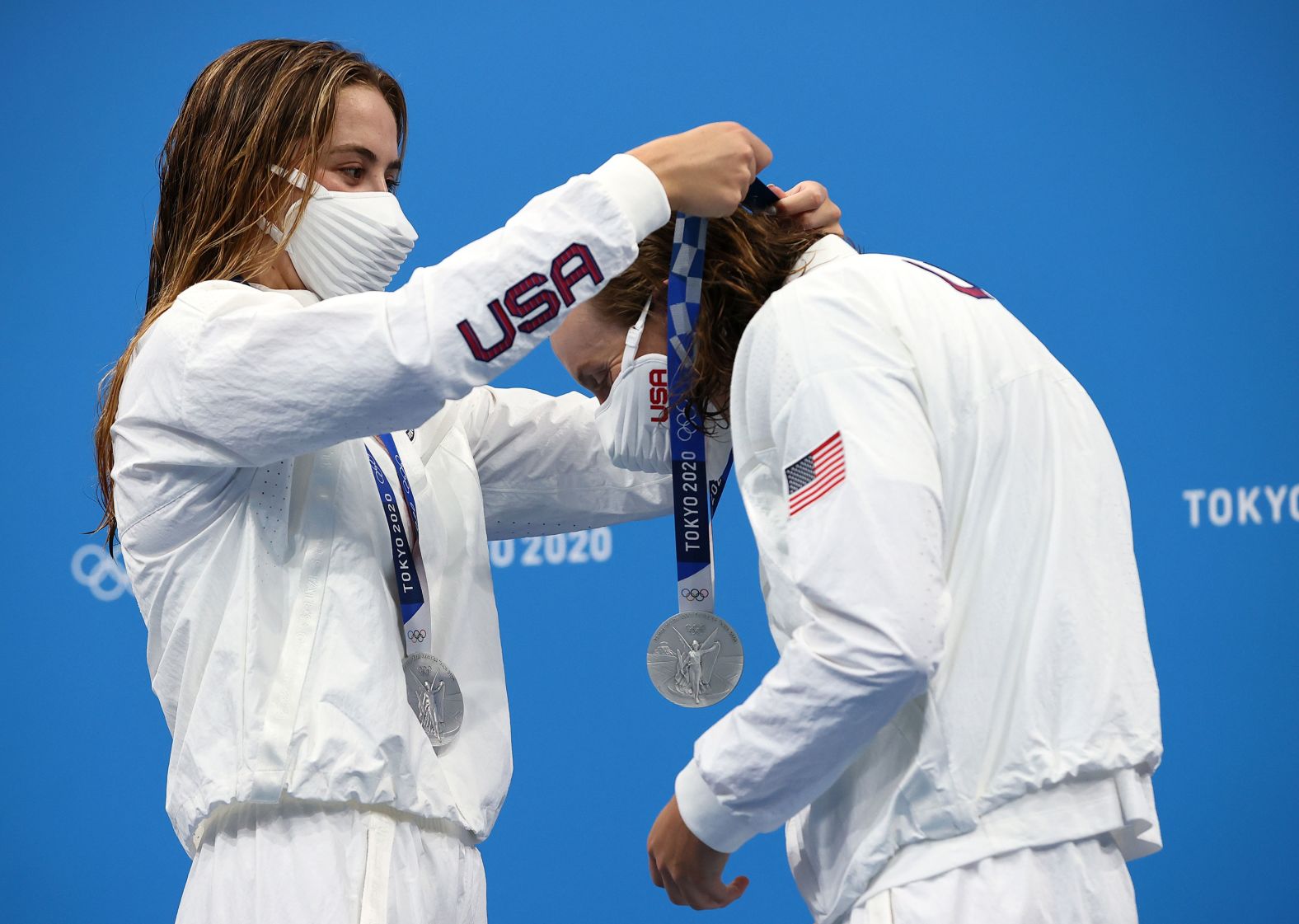 US swimmer Katie McLaughlin places a silver medal around the neck of teammate Katie Ledecky after the 4x200-meter freestyle relay on July 29. The International Olympic Committee created a contactless medal ceremony, asking athletes to put their medals on themselves. Some athletes have been <a href="index.php?page=&url=https%3A%2F%2Fwww.cnn.com%2Fworld%2Flive-news%2Ftokyo-2020-olympics-07-29-21-spt%2Fh_f28d5e8948c5b62f6965c00dcfd35a2f" target="_blank">putting the medal on their teammates.</a>