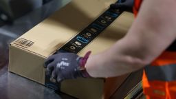 An employee prepares a package for shipment at the Amazon logistics centre in Suelzetal, eastern Germany, on Mai 12, 2021.