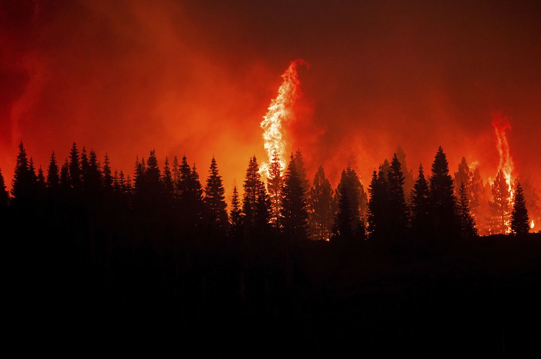 Flames from the Dixie Fire crest a hill in Lassen National Forest on Monday.