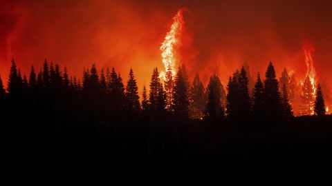 Flames from the Dixie Fire crest a hill in Lassen National Forest on Monday.