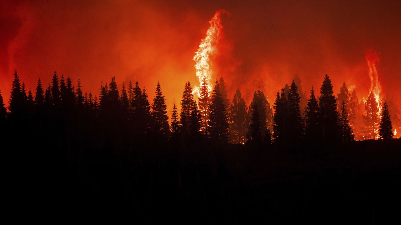 Flames from the Dixie Fire crest a hill in Lassen National Forest, California, near Jonesville on Monday, July 26, 2021.