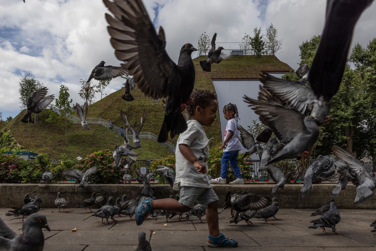 Children run amongst pigeons in front of the Marble Arch Mound in London on Wednesday, July 28. The Marble Arch Mound, which opened on July 26, <a href="https://www.cnn.com/travel/article/london-mound-marble-arch/index.html" target="_blank">has swiftly been branded the city's worst tourist attraction</a> — because rather than being the hoped-for sylvan glade of lush grass and trees sprouting from its sides, it's little more than a mound of earth. The $2.8 million development, which sits on the edge of Oxford Street, had promised sweeping views over London from its panoramic platform, 82 feet and 130 steps up.