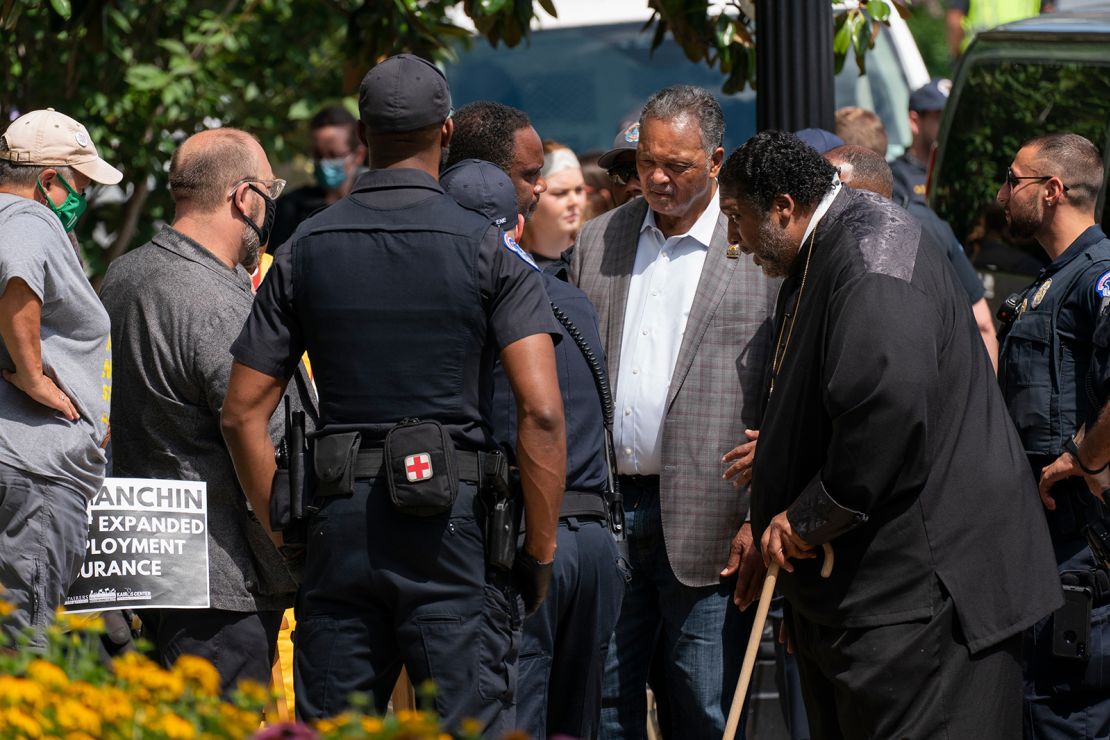 Rev. Jesse Jackson, second from right, and Rev. William Barber II, second from left, stand in front of the Hart Senate Office building in Washington, DC, blocking the street, on June 23.