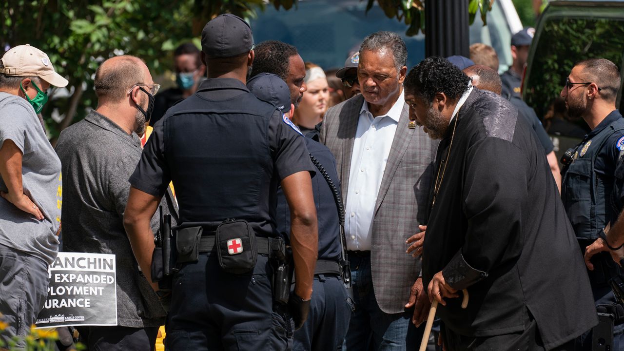 Rev. Jesse Jackson, second from right, and Rev. William Barber II, second from left, stand in front of the Hart Senate Office building in Washington, DC, blocking the street, on June 23.