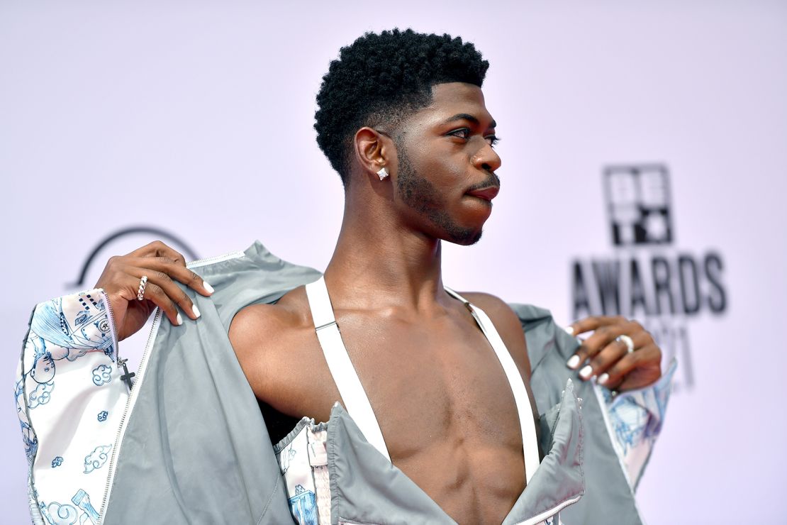 Lil Nas X, seen posing on the red carpet of the BET Awards, is committed to being himself, which could make the music industry a more accepting place for LGBTQ artists, academics told CNN.