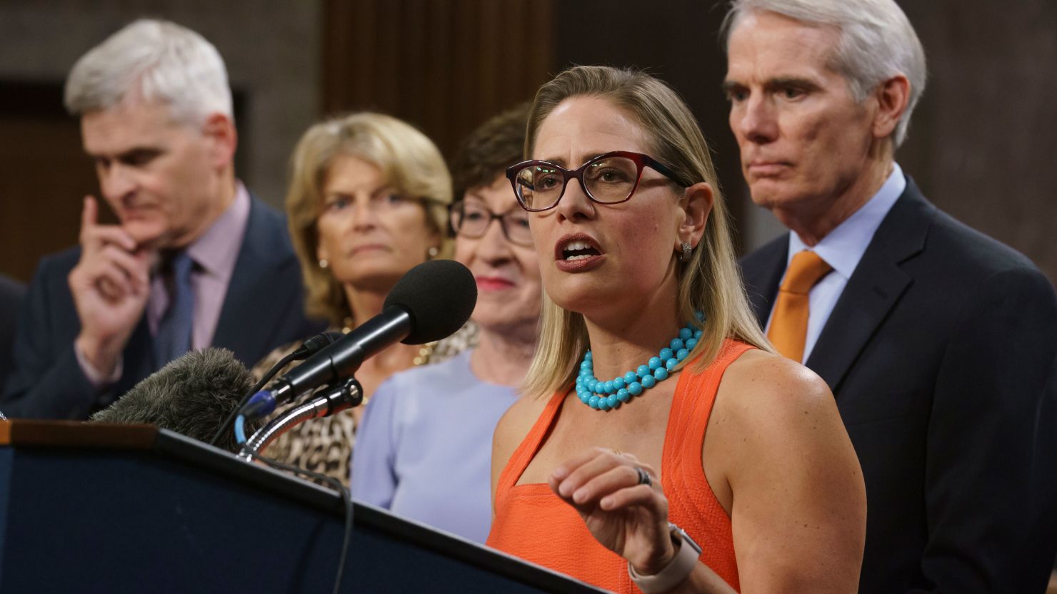 Sen. Kyrsten Sinema, D-Arizona, at center, is joined Wednesday with other senators who negotiated the roughly $1 trillion infrastructure making its way through the Senate. 