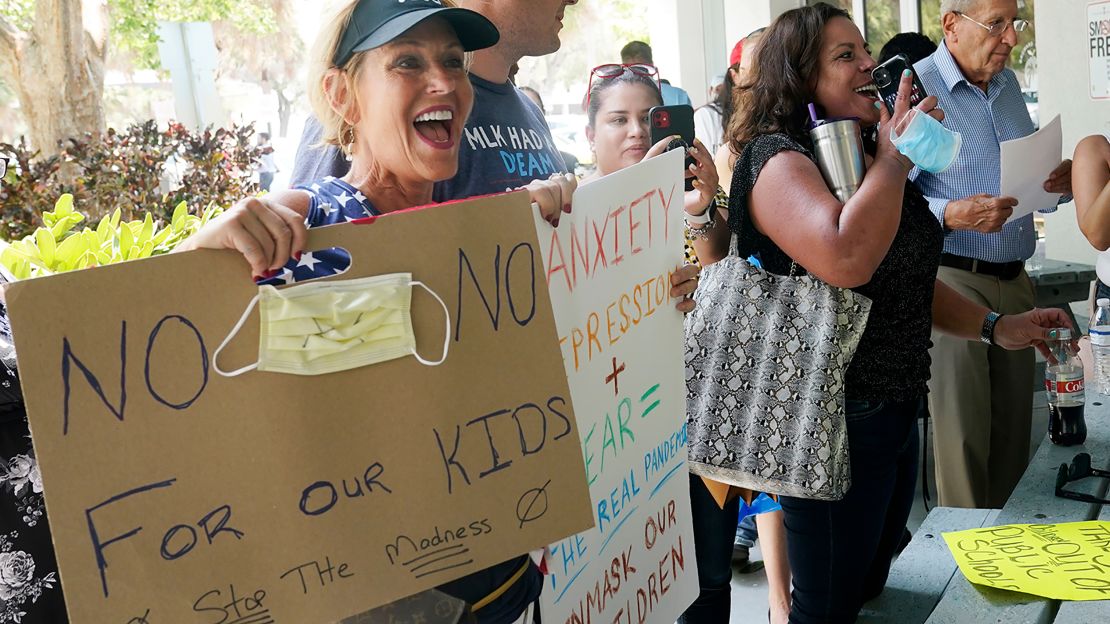 Joann Marcus of Fort Lauderdale, left, cheers as she listens to the Broward School Board's emergency meeting on Wednesday, July 28. A small but vocal group spoke vehemently against masks, saying their personal rights were being eroded and their children were suffering socially. 