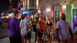 Emma Walton and Maddison Mansfield of Little Rock, Arkansas, walk down Bourbon Street in New Orleans as Covid-19 cases spike. 