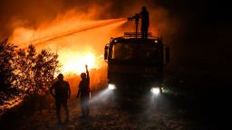 Firefighters pour water as they try to get the fire under control in Kirli village near the town of Manavgat, in Antalya province, Turkey, early Friday July 30, 2021. The fire that continued all night could not be brought under control and people living in the village started to evacuate. Wildfires are common in Turkey's Mediterranean and Aegean regions during the arid summer months, although some previous forest fires have been blamed on arson. (AP Photo)