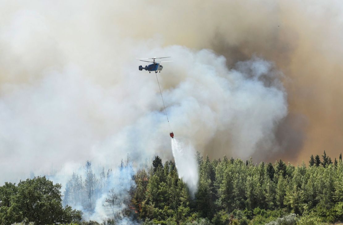A helicopter fights wildfires in Kacarlar village, near the Mediterranean coastal town of Manavgat, on Saturday, July 31.