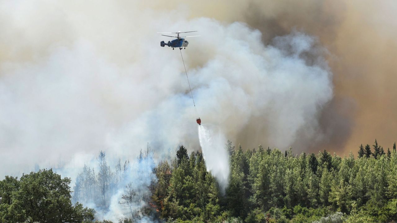 A helicopter fights wildfires in Kacarlar village, near the Mediterranean coastal town of Manavgat, on Saturday, July 31.