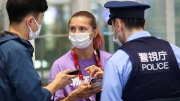 Belarusian athlete Kristina Timanovskaya talks with a police officer at Haneda international airport in Tokyo, Japan August 1, 2021.  REUTERS/Issei Kato