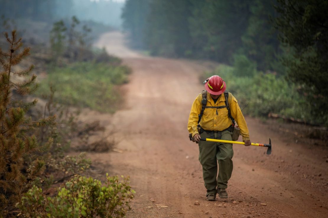 A firefighter from New Mexico walks up a dirt road after working to help contain the Bootleg Fire near Silver Lake, Oregon, on July 29, 2021. 