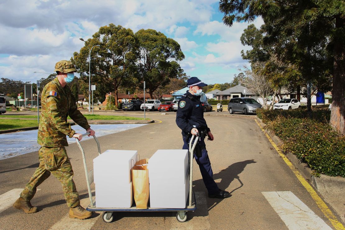 Australian Defence Force personnel and NSW police load food packages for delivery to people in lockdown at the Prairiewood Leisure Centre in Sydney on August 2.