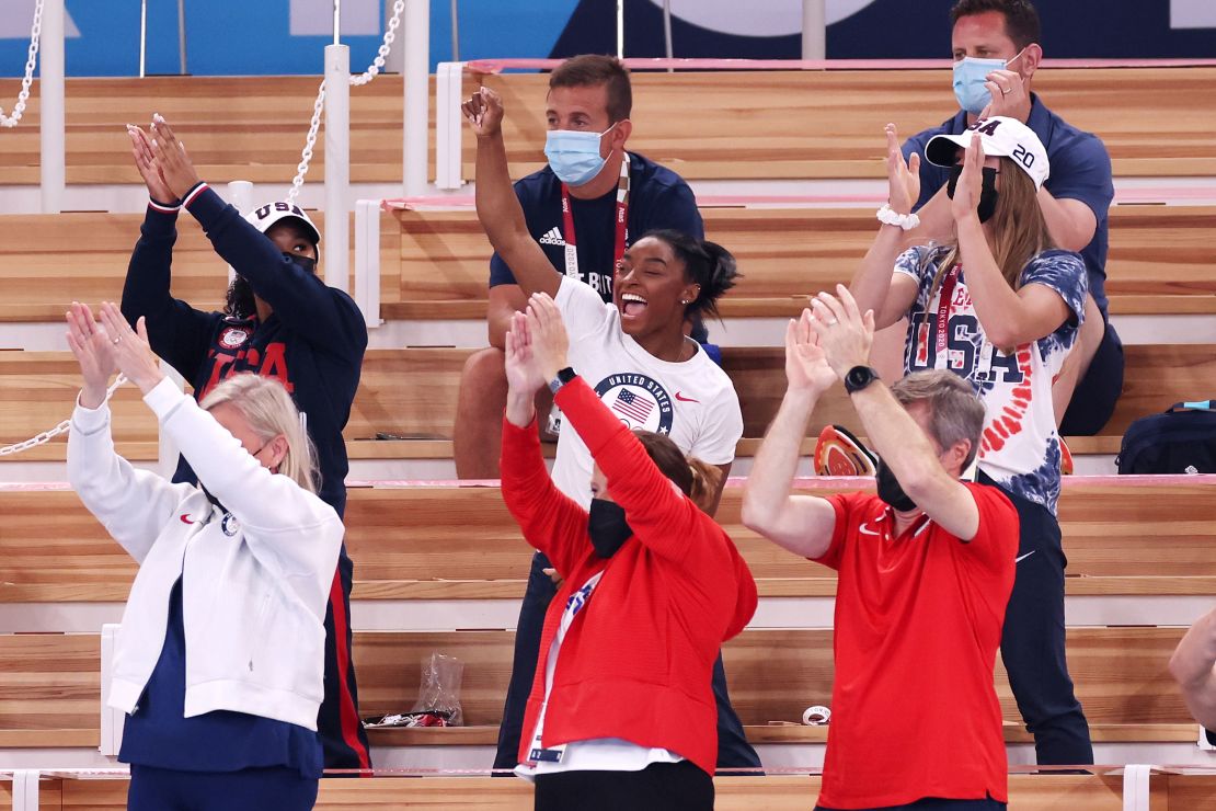 Biles cheers with teammates Jordan Chiles (left) and Grace McCallum (right) from the stands during the women's vault final.